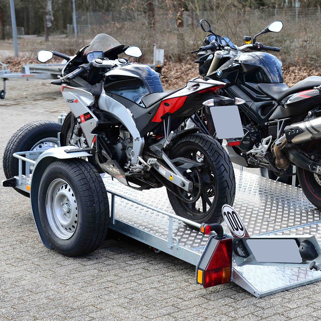 zwei Harley Davidson Motorräder auf offenem Anhänger zum Transport